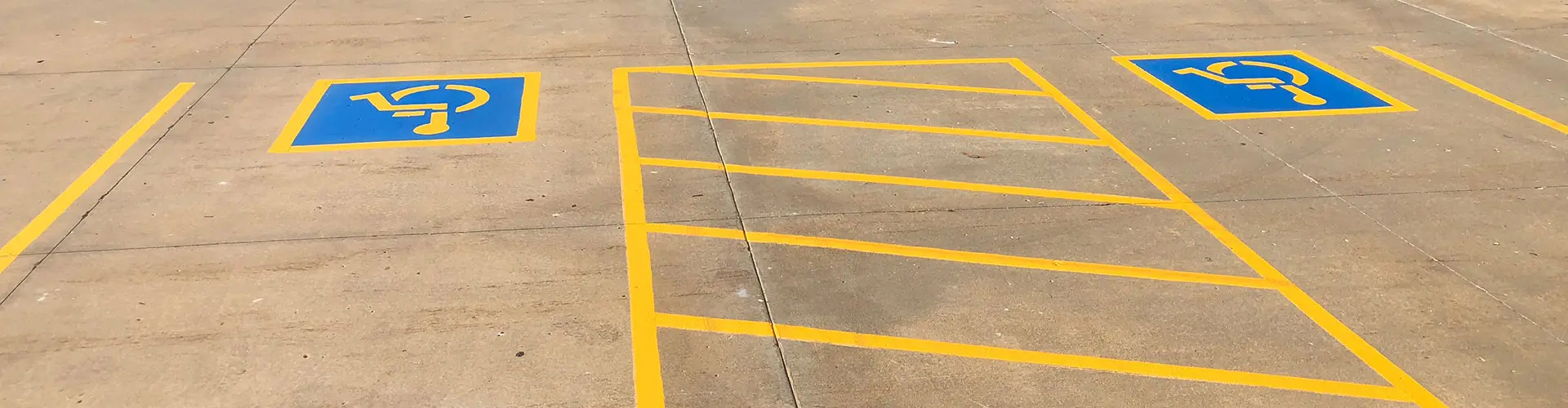 Two handicapped spaces in a parking lot, separated by an access aisle.