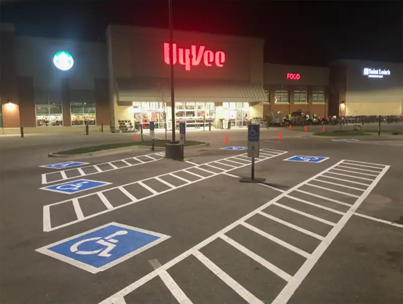 A Hy-Vee store parking lot with freshly painted handicapped parking spaces and access aisles.