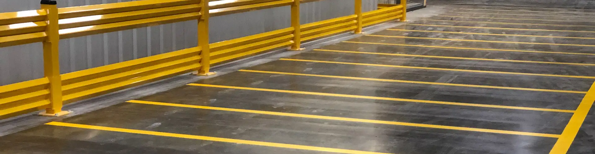Long yellow lines subdivide part of a warehouse floor.